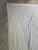 A large off-white canvas sheet or tarp with visible wrinkles, laid out on a concrete floor.
